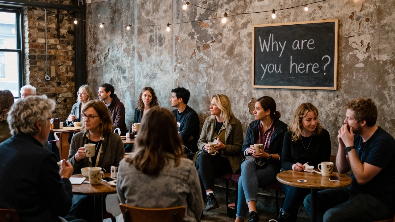 A diverse group of people sipping tea at an open house event, chatting softly in a warehouse with no phones or merch.
