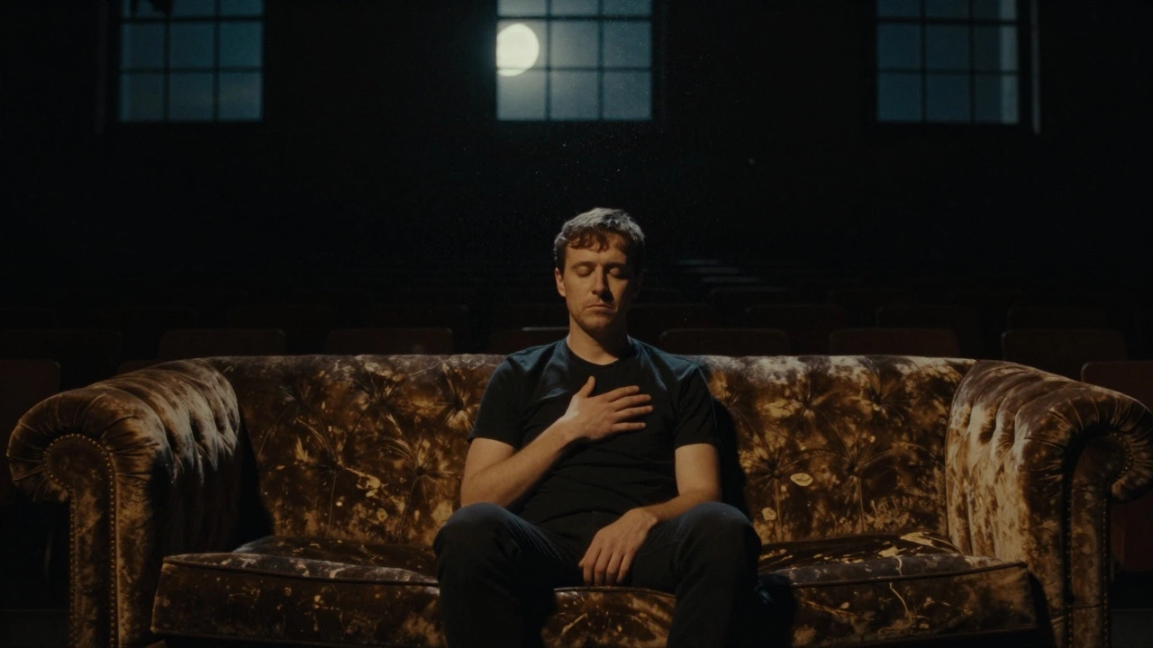 A person sitting alone after a performance, eyes closed, surrounded by silence and drifting dust motes in moonlight.